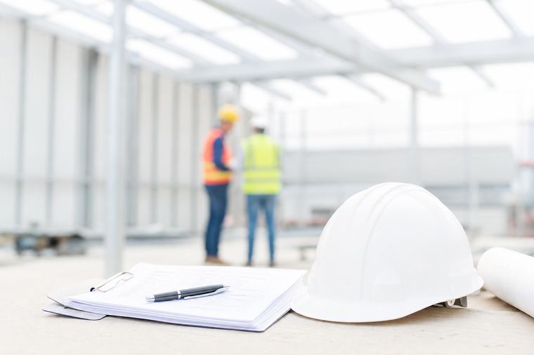 Una persona in piedi accanto a una struttura metallica bianca montata in un cantiere.